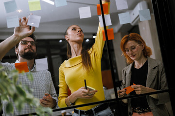 Creative team brainstorming strategies during a collaborative session in a modern office space with colorful sticky notes