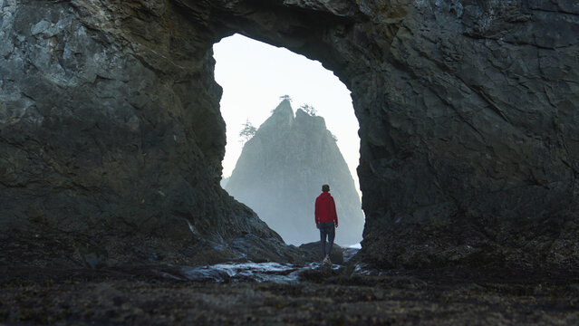 Person at the hole in the wall at Rialto Beach in Washington, USA