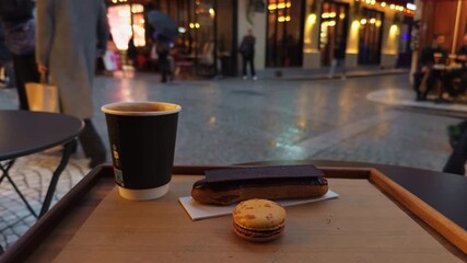 Enjoy a delightful urban outdoor coffee break that includes a tasty pastry and a delicious macaron treat