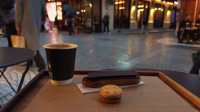 Enjoy a delightful urban outdoor coffee break that includes a tasty pastry and a delicious macaron treat