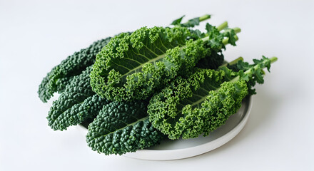 Assortment of fresh curly and Lacinato kale leaves on a white ceramic plate, healthy green vegetables, food variety