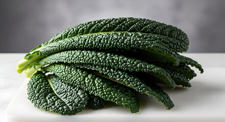 Fresh dark green Lacinato kale bunch on a white cutting board, ready for food preparation and healthy cooking