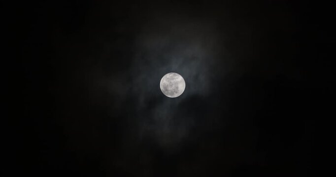 Thin layers of cloud slightly covering the full moon