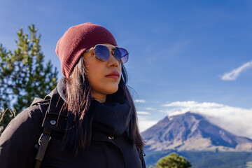 Woman hiking in mountains overlooking volcano popocatepetl