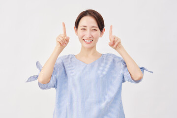 女性　ミドルエイジ　上を指差す　白背景