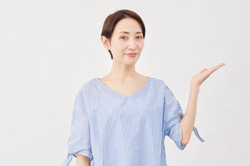 女性　ミドルエイジ　手のひらで右を指す　白背景