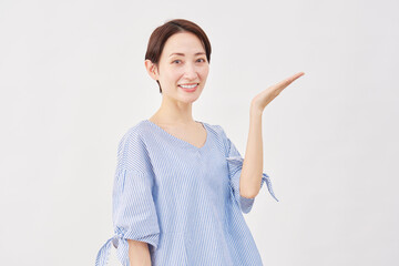女性　ミドルエイジ　手のひらで右を指す　白背景