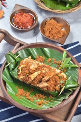 Grilled rice with shredded chicken and spiced grated coconut, wrapped in banana leaves, a traditional Indonesian dish