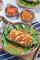 Grilled rice with shredded chicken and spiced grated coconut, wrapped in banana leaves, a traditional Indonesian dish