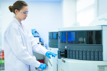 A clinical scientist initiates a batch test on a high-throughput immunoassay analyzer, loading patient samples for large-scale screening of diseases, hormones, or other biomarkers. © ultramansk