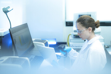 In a future paperless lab a data scientist provides final human oversight as an AI system automatically audits and validates data integrity between instruments and a blockchain ledger.