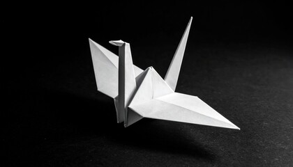 Elegant white origami crane perched gracefully against a dark backdrop, symbolizing peace and creativity