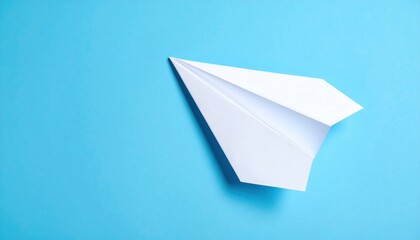 A simple white paper airplane resting on a vibrant blue background, symbolizing creativity and flight
