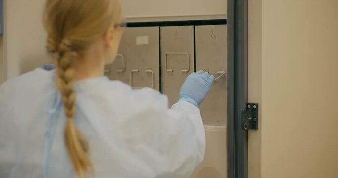 Female Scientist Opening Laboratory Freezer for Research
