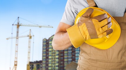 Naklejka na ściany i meble Safety workwear hold safety helmet at construction