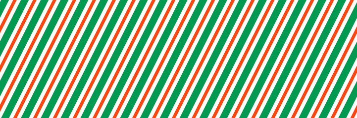 Striped Christmas seamless pattern. Red and green diagonal lines wallpaper. Winter holiday gift wrapping paper design. Xmas candy cane peppermint repeating background. Vector decoration backdrop
