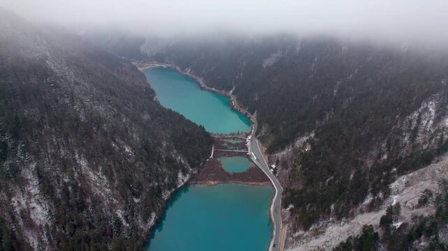 Drone view of Jiuzhaigou National Park in spring in Sichuan Province China. It features cascading waterfalls, turquoise blue lakes, and stunning mountain valleys. 4K real time footage travel concept.