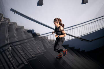 Woman running up urban stairs exercising for fitness