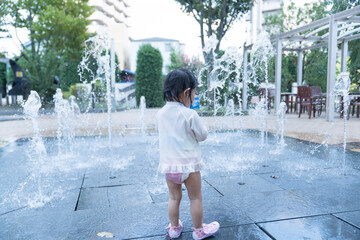 マンション広場の噴水で遊ぶ日本人の幼児