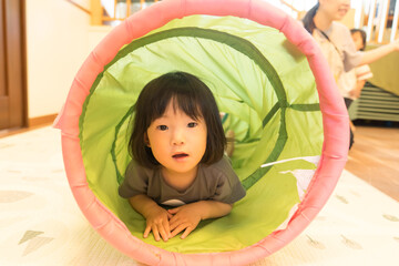 トンネルの遊具で遊ぶ女の子の幼児
