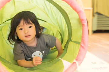 トンネルの遊具で遊ぶ女の子の幼児