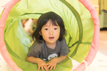 トンネルの遊具で遊ぶ女の子の幼児