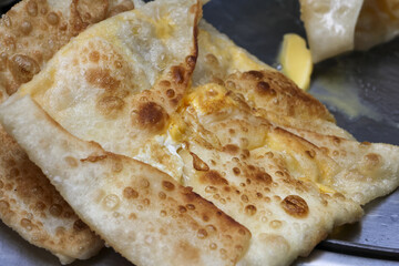 Close up of delicious Roti Prata or Roti Canai, tasty Asian cuisine for breakfast. Savory, crispy, and folded Indian flatbread meal, popular and traditional street food