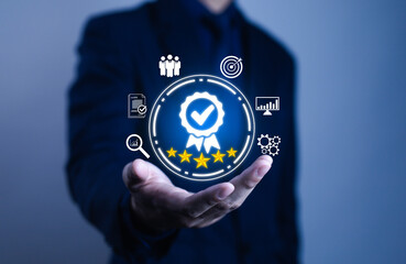 Businessman holding digital icon of quality assurance and five-star rating, representing customer satisfaction, service excellence, certification, ISO standards, and professional business performance.