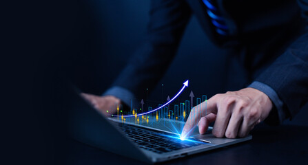 Businessman using laptop with growing digital graph and rising arrow, representing business growth, financial success, data analysis, investment strategy, and modern digital marketing concept.