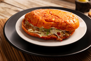 Pambazo. Sandwich marinated in sauce and roasted on a comal traditionally stuffed with potatoes and chorizo, a classic of Mexican street food.