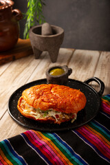 Pambazo. Sandwich marinated in sauce and roasted on a comal traditionally stuffed with potatoes and chorizo, a classic of Mexican street food.