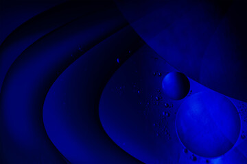 Macro photography of floating oil bubbles in blue fluid