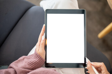 Close up of woman artist or student's hands holding tablet with stylus while sitting on sofa in cafe