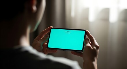 Person holding a smartphone with a green screen in landscape orientation.