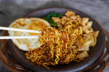 Grilled Chili Noodles, captured on October 8, 2025. Spicy stir-fried noodles charred over flames, topped with fresh herbs and chili, vibrant Indonesian street food scene