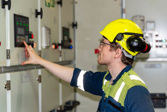 Young marine engineer during his daily routine work in engine room. Seafarers life.