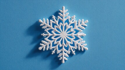 Minimal Snowflake on Bright Blue Background. Flat Lay Season Concept.