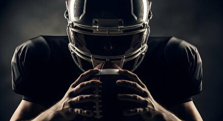 Intense determination on a football player's face as he grips the ball, ready for victory and focused on team success during a competitive game