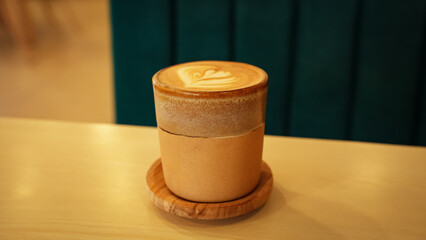 A cup of hot latte coffee on the table for breakfast