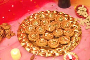 Chandrakala beautifully decorated in a golden plate with festive celebration background