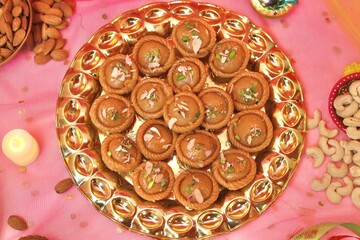 Chandrakala beautifully decorated in a golden plate with festive celebration background
