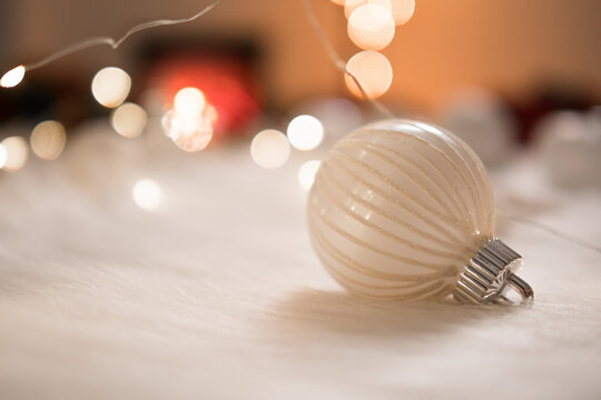 Beautiful white christmas ball on wool with bokeh lights background.