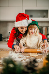 Mother and daughter baking christmas cookies together