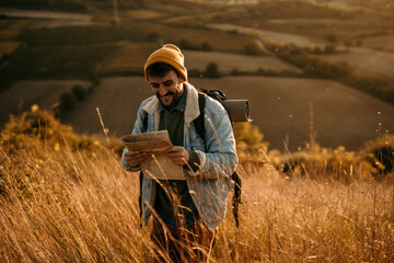 Man hiking and looking at map enjoying nature adventure