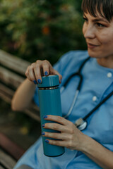 Healthcare worker relaxing during break holding thermos