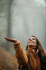 Woman enjoying foggy forest nature hike