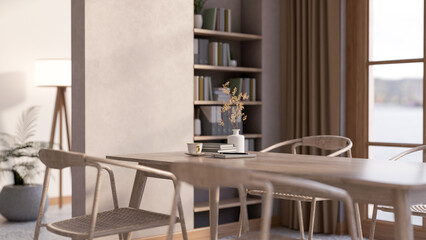 Coffee cup with books and vase on wooden table with chair aside wall shelf and window in living room