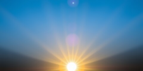 Bright sunburst with lens flare against a gradient blue sky at sunrise or sunset