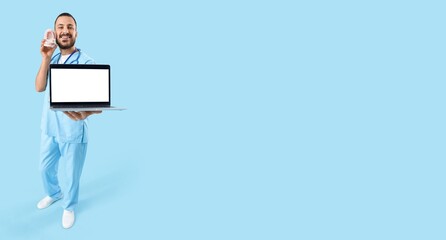 Male dentist holding laptop on light blue background with space for text