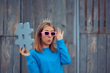 Social Media Influencer with Crown and Hashtag Symbol. Cheerful woman being successful as an online content creator 

